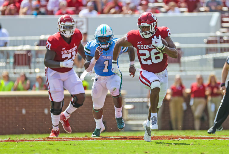 Sep 4, 2021; Norman, Oklahoma, USA; Oklahoma Sooners running back Kennedy Brooks (26) runs with the ball as Tulane Green Wave linebacker Nick Anderson (1) chases during the second quarter at Gaylord Family-Oklahoma Memorial Stadium. Mandatory Credit: Kevin Jairaj-USA TODAY Sports