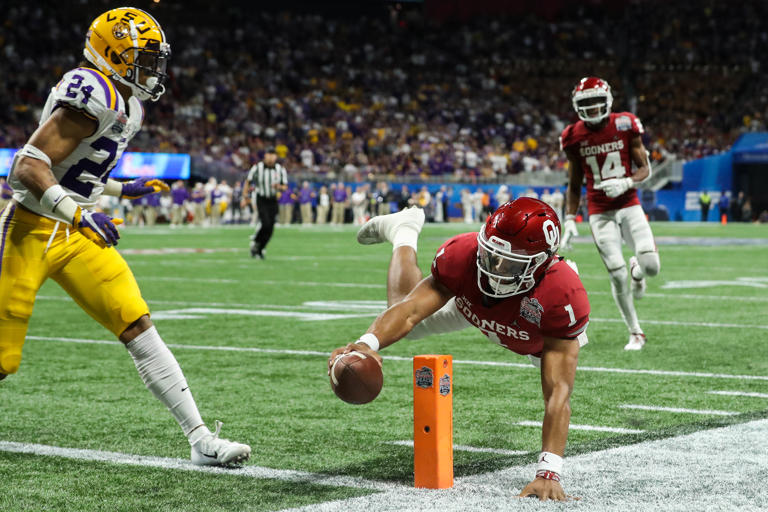 Dec 28, 2019; Atlanta, Georgia, USA; Oklahoma Sooners quarterback Jalen Hurts (1) scores a touchdown ahead of LSU Tigers cornerback Derek Stingley Jr. (24) during the third quarter of the 2019 Peach Bowl college football playoff semifinal game at Mercedes-Benz Stadium. Mandatory Credit: Jason Getz-USA TODAY Sports